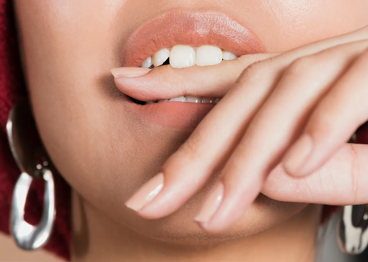 extreme-close-up-shot-young-woman-bitting-her-finger
