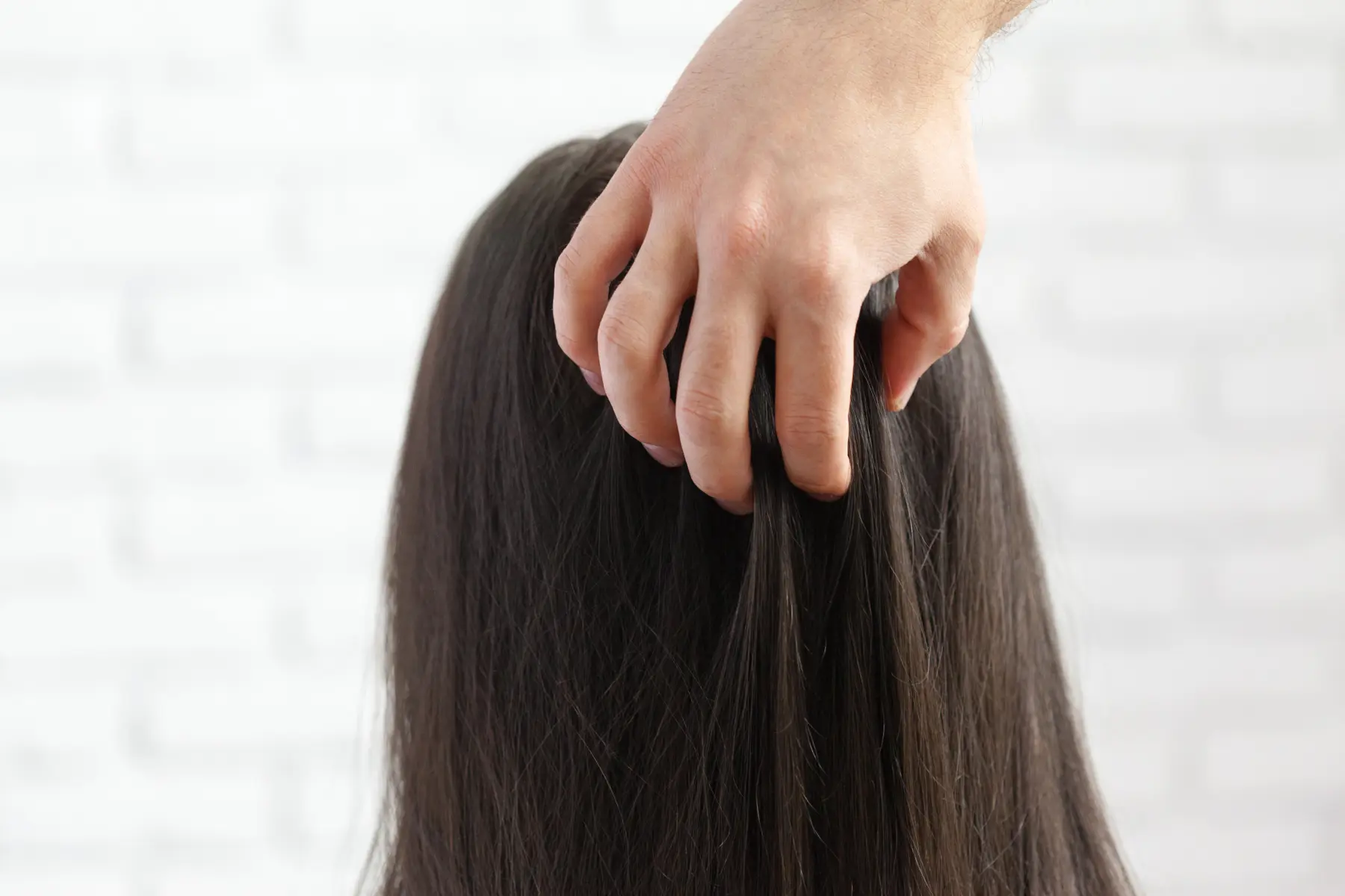 hand-gently-touching-long-dark-hair-against-textur-2026-05-28-21-13-34-utc