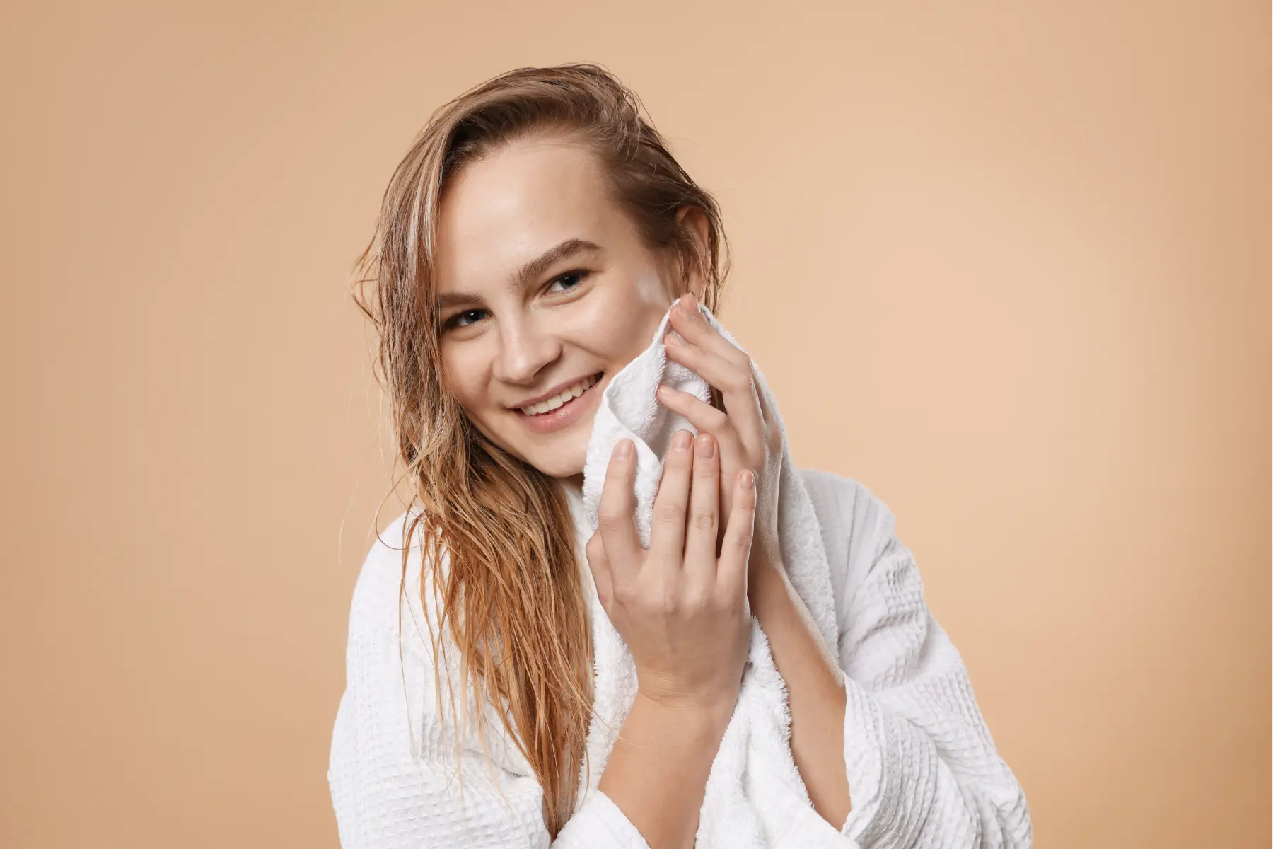 smiling-woman-drying-hair-with-towel-in-studio-2026-04-15-16-29-03-utc