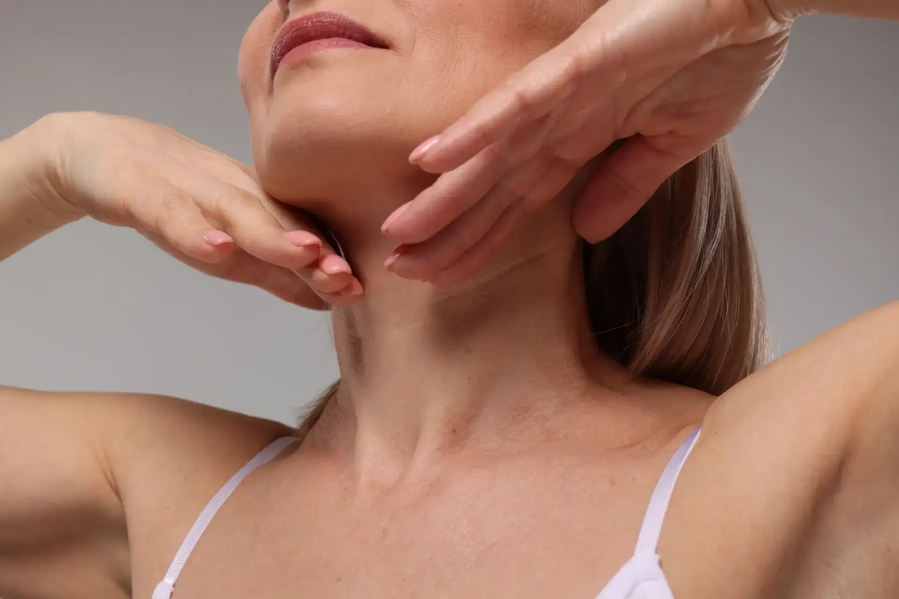 woman-gently-massaging-her-neck-and-shoulders-2026-04-08-16-19-05-utc