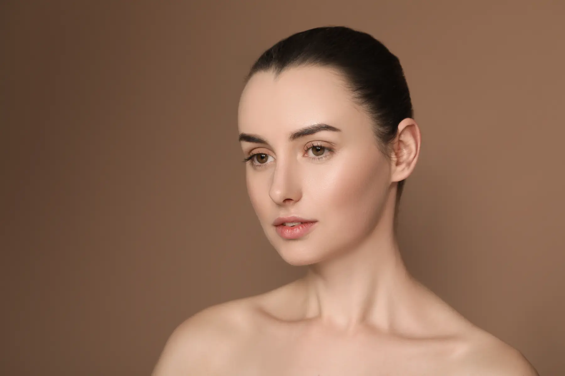 woman-s-head-and-shoulders-against-warm-brown-back-2026-06-16-06-27-36-utc