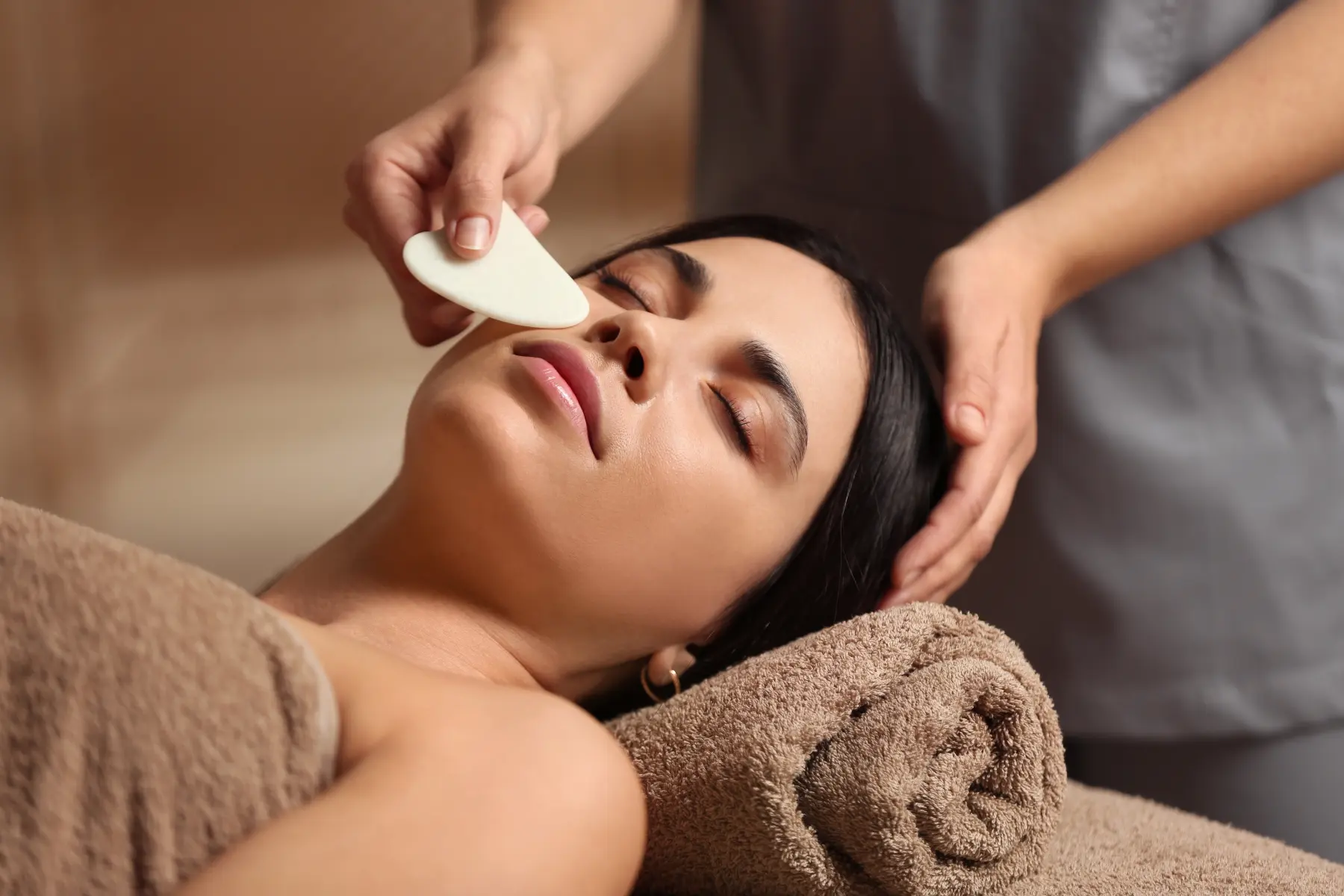 young-woman-receiving-facial-massage-with-gua-sha-2026-01-11-11-09-11-utc